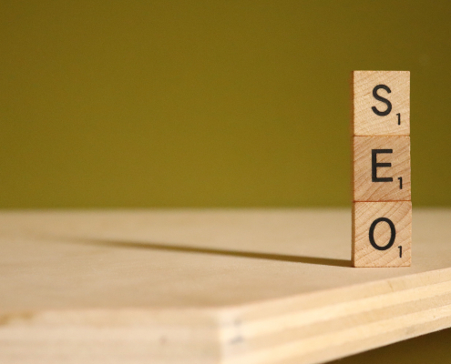 Das Bild zeigt drei Holzsteine, auf denen die Buchstaben SEO zu sehen sind. SEO ist auch für Amazon wichtig, Backend-Keywords tragen einen entscheidenden Beitrag dazu bei.