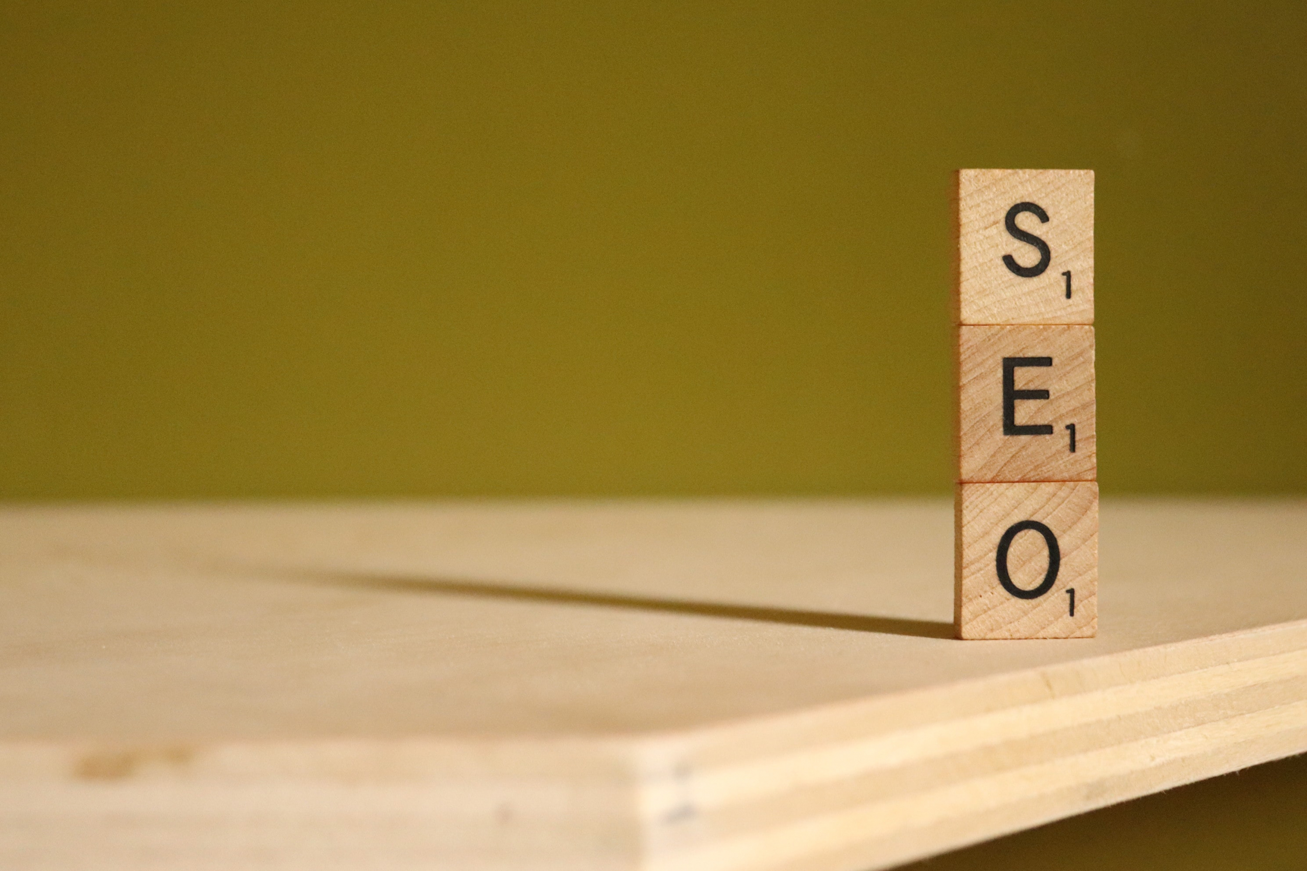 Das Bild zeigt drei Holzsteine, auf denen die Buchstaben SEO zu sehen sind. SEO ist auch für Amazon wichtig, Backend-Keywords tragen einen entscheidenden Beitrag dazu bei.