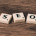 Auf dem Bild sind weiße Spielsteine mit Buchstaben zu sehen, die das Wort SEO bilden. SEO steht für Search Engine Optimization, die auch in Form der Amazon SEO für den Marktplatz betrieben wird.
