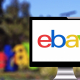 Das Foto zeigt im Vordergrund einen Monitor mit dem eBay-Logo. Im Hintergrund ist das Logo noch einmal verschwommen zu sehen.