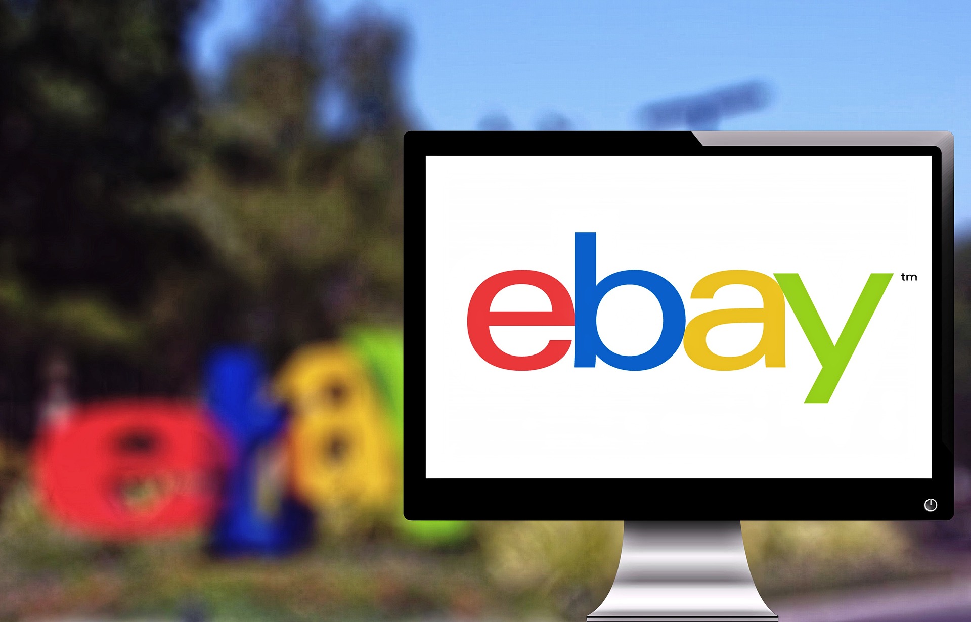 Das Foto zeigt im Vordergrund einen Monitor mit dem eBay-Logo. Im Hintergrund ist das Logo noch einmal verschwommen zu sehen.