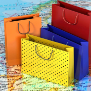Einkaufstüten in verschiedenen Farben auf einer Europakarte symbolisieren internationalen B2B-Handel über Amazon.
